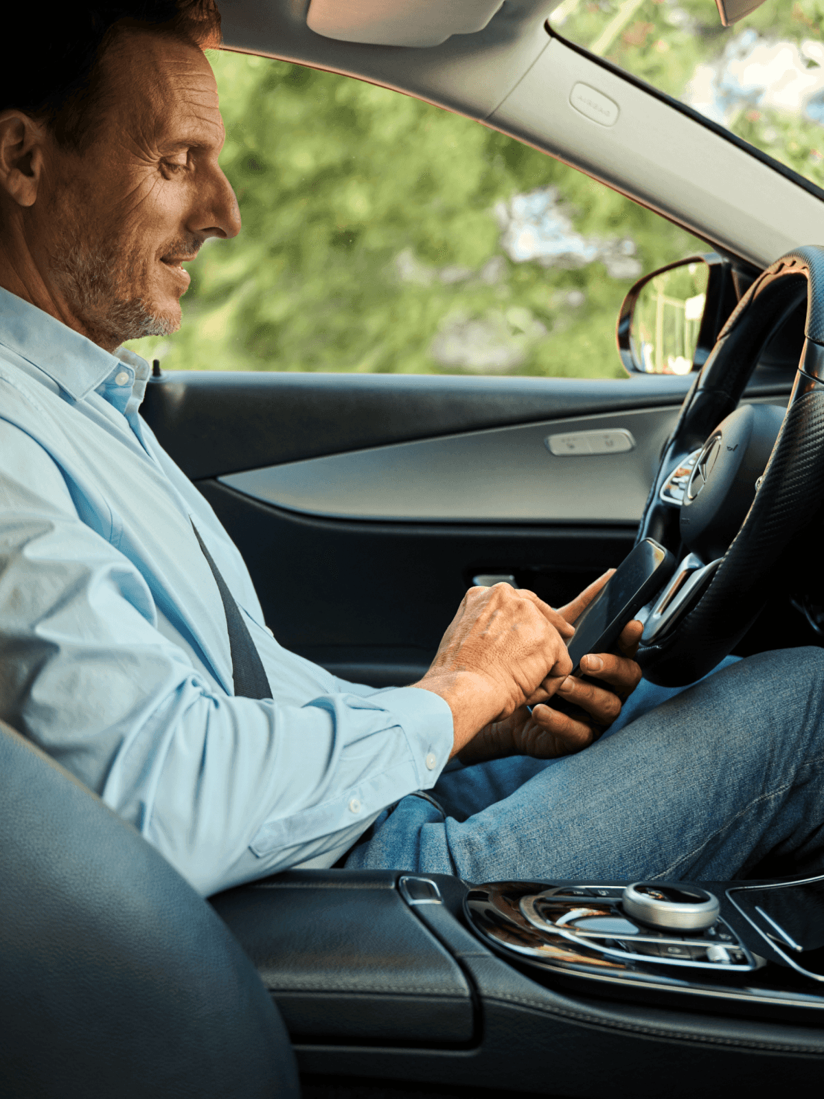 driver sitting in taxi checking phone
