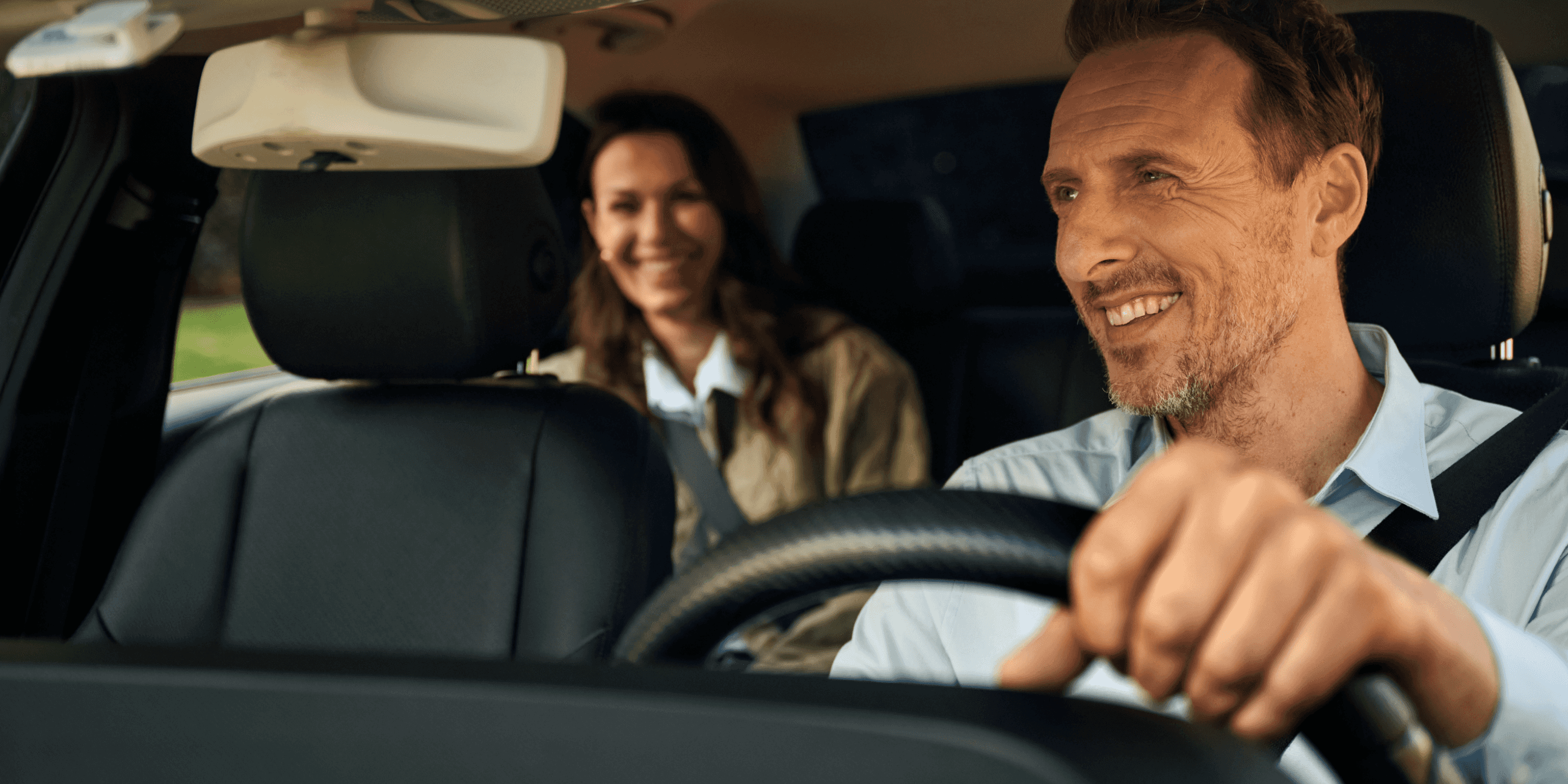 Freenow taxi driver and passenger smiling in taxi