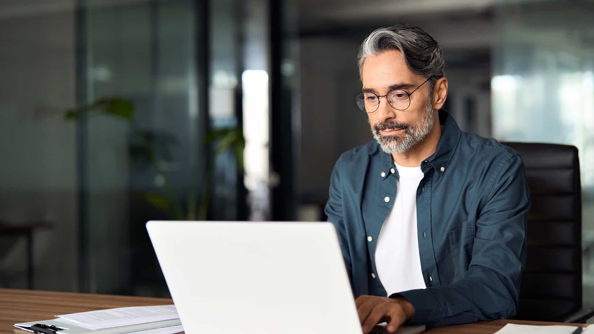 man in glasses looking at laptop