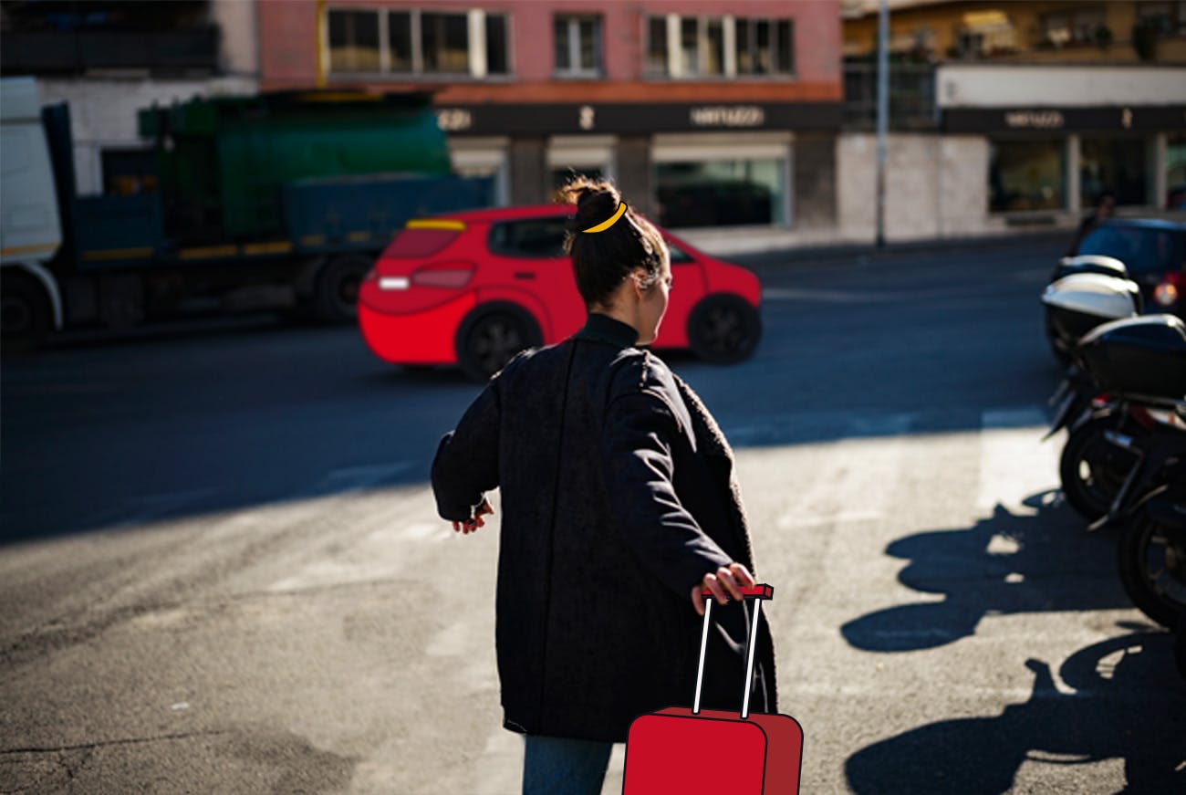 Una dipendente che tira la sua valigia verso un taxi in attesa che ha prenotato come benefit per i dipendenti.