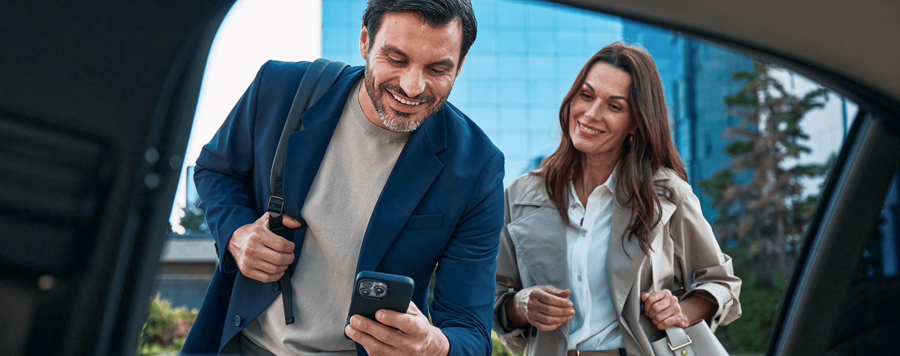 Two business travellers ordering a Freenow taxi via app