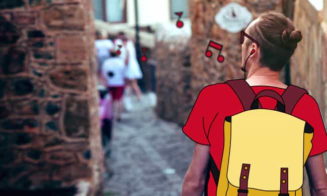 Employee walking in a narrow street on holiday listening to music.