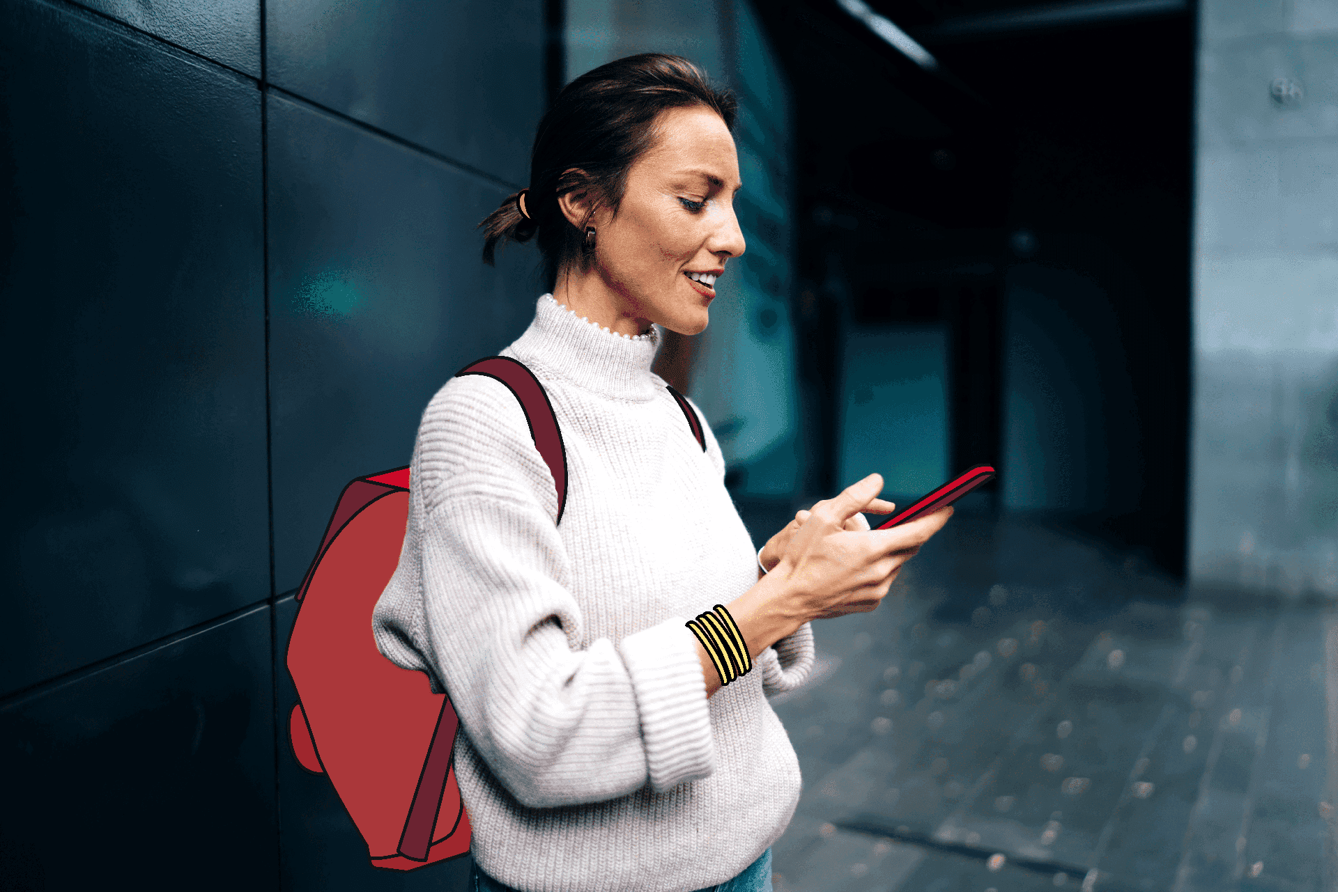 Una mujer con mochila mira a su teléfono móvil