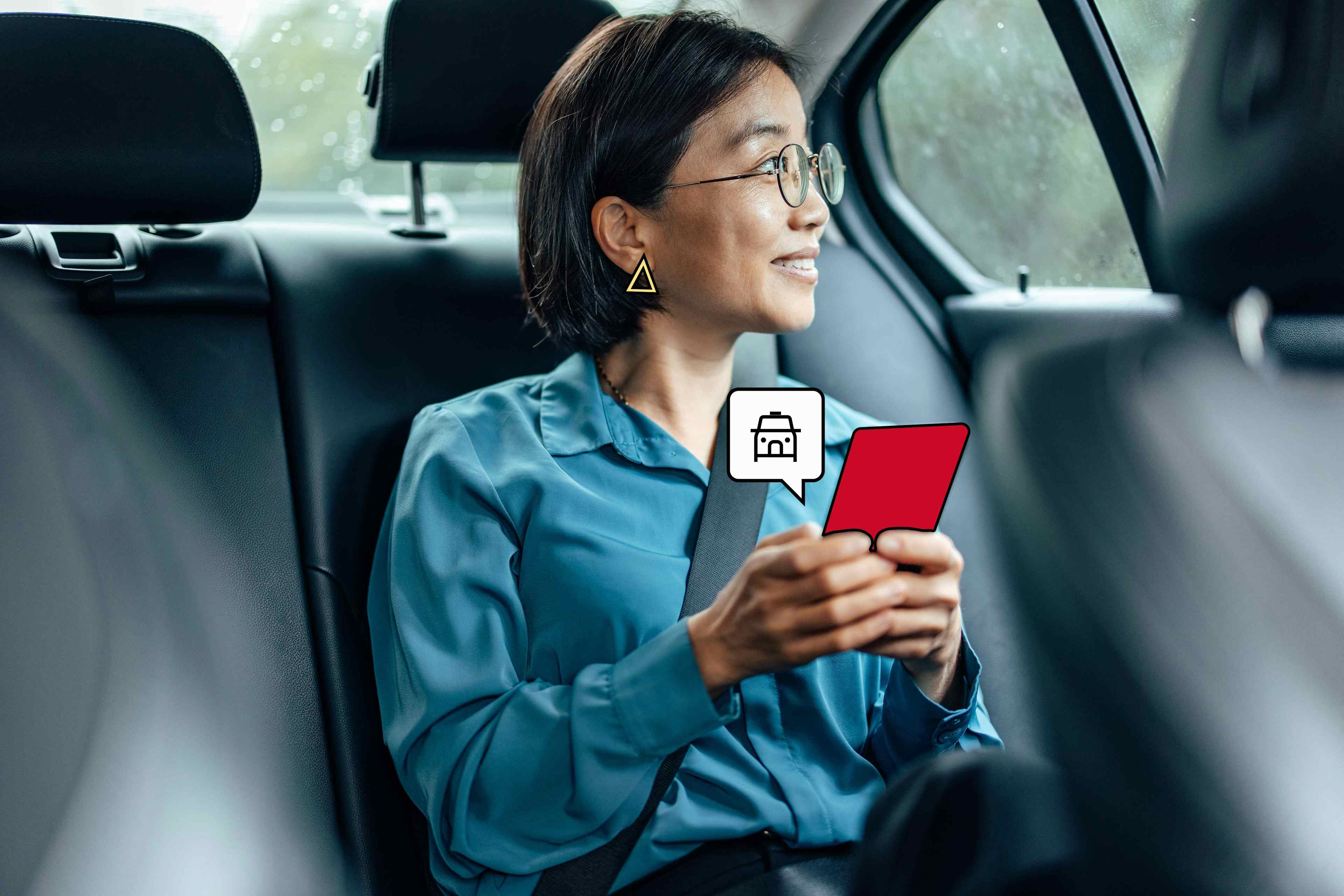 Voyageuse d'affaires assise dans un taxi en route pour un voyage d'affaires, tenant son téléphone portable sur l'application FREENOW.